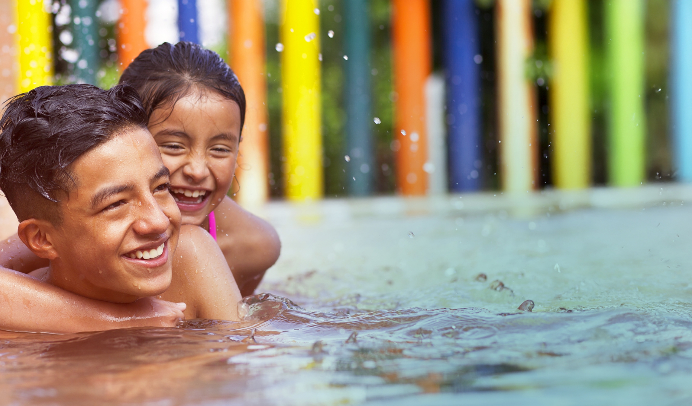 brother and sister play in the pool with a colorful backdrop - full range of amenities is part of the vision for Hilliard Isle