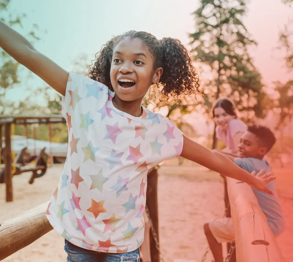 children play together on a wooden structure at a community park