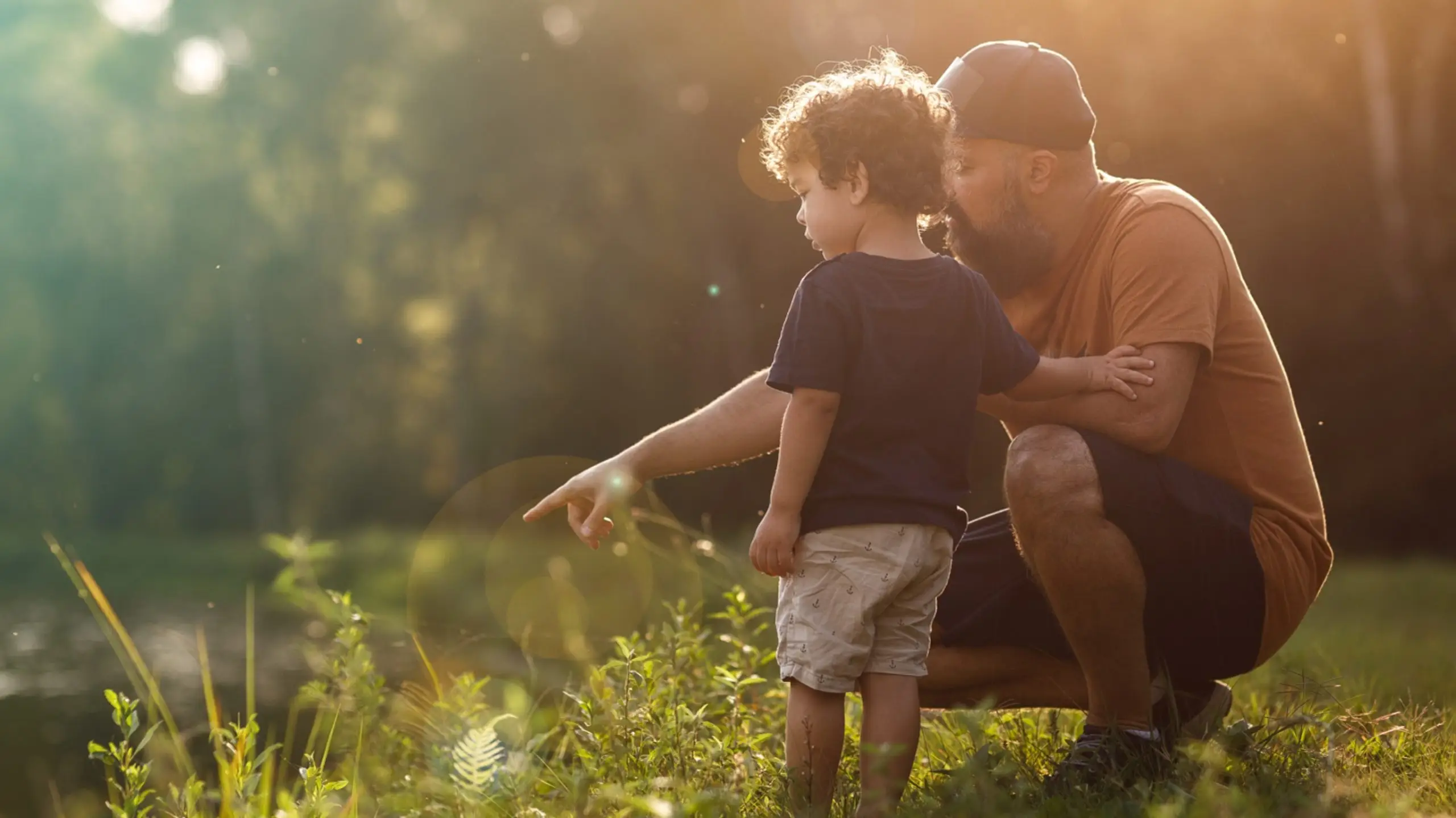 father points to into the lake to show his young son something in the water - a slice of life at Hilliard Isle - new homes for sale in Kissimmee Florida